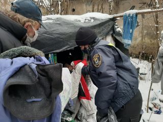 Strażniczka miejska przekazuje odzież osobie bezdomnej