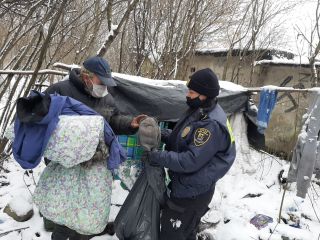 Strażniczka miejska przekazuje odzież osobie bezdomnej