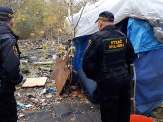 Strażnicy miejscy podczas kontroli miejsca przebywania osób bezdomnych