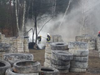 Strażnicy miejscy i strażacy poodczas akcji gaszenia palących się  opon w rejonie ulicy Goetla
