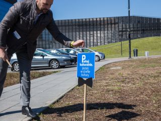 Naczelnik Wydziału Promocji prezentuje tabliczkę informacyjną