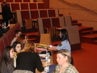 Strażniczka miejska przekazuje opaski odblaskowe studentom