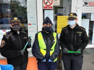 Policjantka i strażniczki miejskie przed budynkiem szkoły