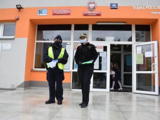 Policjantka i strażniczka miejska przed budynkiem szkoły