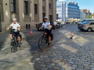 Strażnicy miejscy jadący na elektrycznych rowerach