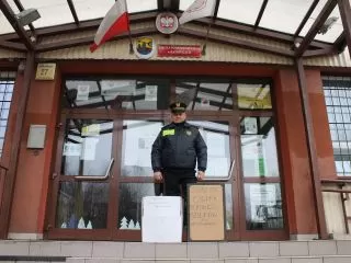 Strażnik miejski z darami dla bezdomnych zebranych przez uczniów Szkoły Podstawowej nr 64