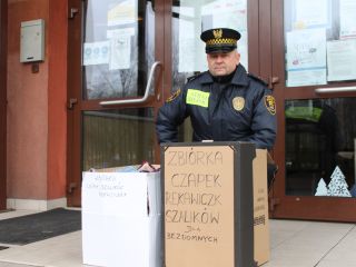 Strażnik miejski z darami dla bezdomnych zebranych przez uczniów Szkoły Podstawowej nr 64