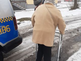 Strażniczka miejska pomaga seniorce podczas przejścia do punktu sczepień