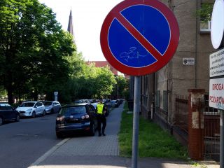 Strażniczka miejska podczas wykonywania czynności przy nieprawidłowo zaparkowanym pojeździe