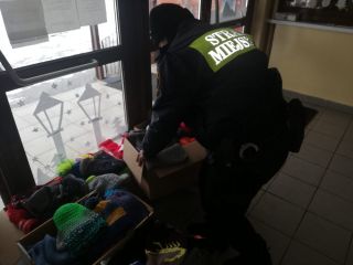 Strażniczka miejska odbiera zebraną przez uczniów odzież