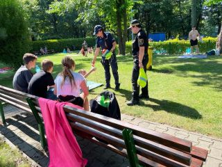 Strażniczka miejska i policjant rozdający upominki dzieciom