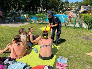 Policjantka wręcza upominki dzieciom