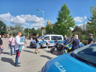 Rodzice, dzieci, mundurowi i maskotki przed szkołą