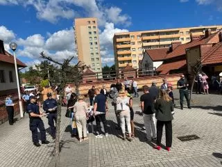 Rodzice, dzieci, mundurowi i maskotki przed szkołą